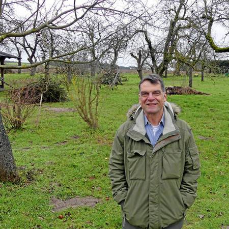 Manfred Uhlig an einem für ihn sehr wichtigen Ort: im Obstgarten seiner Schwiegereltern, die es ebenfalls nach Vietze gezogen hat. Für den 64-jährigen Filmemacher bedeutet das Dorf an der Elbe inzwischen tatsächlich: Heimat. 